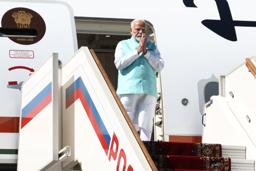 　モスクワ郊外の空港に到着し、タラップで合掌するインドのモディ首相＝８日（タス＝共同）