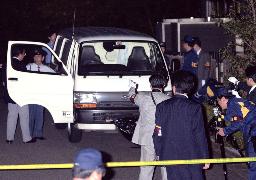 　襲われた現金輸送車とその周辺を調べる捜査員＝２００１年１０月、東京都小平市花小金井