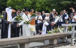 　平和記念公園の慰霊碑に献花する河野デジタル相（左から２人目）や宗教者ら＝１０日午前、広島市