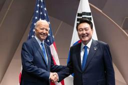 　１１日、ワシントンで握手するバイデン米大統領（左）と韓国の尹錫悦大統領（聯合＝共同）