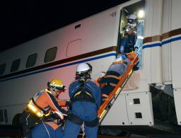 　地震で北陸新幹線が脱線したとの想定で乗客を救護する訓練を行う消防隊員ら＝１２日未明、石川県小松市