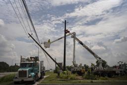 　電線を修理する作業員＝１１日、米南部テキサス州ヒューストン（ゲッティ＝共同）