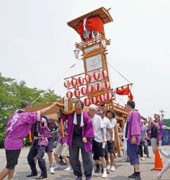 　復興祈願のイベントで「キリコ」を担いで祭りを再現する人たち＝１３日午前、石川県珠洲市宝立町