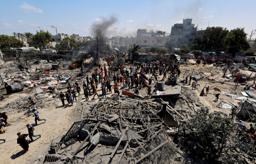 　１３日、パレスチナ自治区ガザ南部ハンユニス西方のマワシ地区で、破壊された難民キャンプに集まった人々（ロイター＝共同）