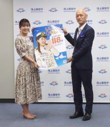 　１１８番の啓発ポスターを報道陣にアピールするタレントの小野あつこさん（左）と海上保安庁の瀬口良夫長官＝１７日午後、東京・霞ケ関