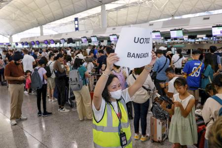 　１９日、システム障害が発生した香港の国際空港でカウンター前に並ぶ乗客（ロイター＝共同）