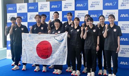 　出国前に写真撮影に応じるバドミントンのパリ五輪日本代表選手たち＝２０日、羽田空港