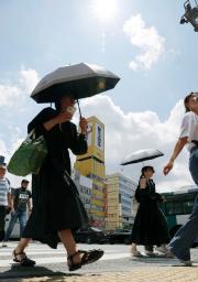 　強い日差しの中、日傘を差して歩く人たち。気象庁は山口県を含む九州北部が梅雨明けしたとみられると発表した＝２２日午前、福岡市