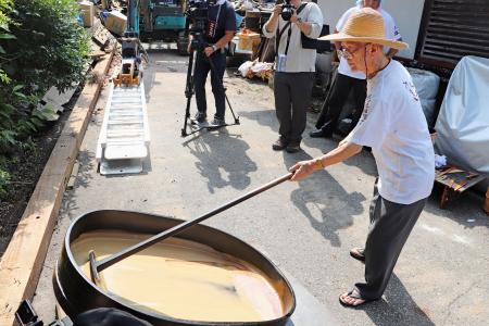 　「天日黒目」の作業で漆の樹液をかき混ぜる大徹八井漆器工房の八井汎親会長＝２３日午前、石川県輪島市