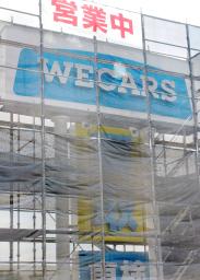 　かけ替え工事が進む「ＷＥＣＡＲＳ（ウィーカーズ）」が設置した新会社名の看板＝２４日午前、東京都多摩市