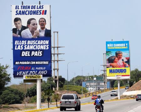 　ベネズエラの首都カラカスに立てられたマドゥロ大統領支持を呼びかける看板。手前は野党を批判する内容＝２６日（共同）