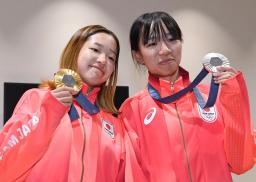 　パリ五輪から帰国し、記者会見でメダルを手に笑顔を見せるスケートボード女子ストリート金の吉沢恋（左）と銀の赤間凜音＝３１日午後、羽田空港