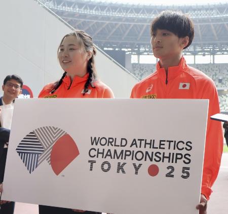 　東京で開催される陸上世界選手権の大会ロゴを手に、取材に応じる女子やり投げの北口榛花（左）＝５月、東京・国立競技場