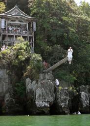 　「伊崎の棹飛び」で琵琶湖に飛び込む僧侶＝１日午後、滋賀県近江八幡市