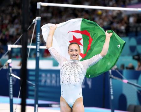 　女子種目別段違い平行棒で優勝し、国旗を手に喜ぶアルジェリアのネムール＝パリ（共同）