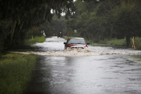 　５日、米南部フロリダ州でハリケーン「デビー」上陸後、冠水した道路を走行するトラック（ロイター＝共同）