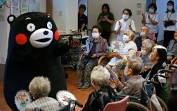 　石川県珠洲市のデイサービス施設を訪れた「くまモン」。右端は中平ひふみさん＝６日午後