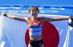 　女子マラソンで６位に入り、笑顔で日の丸を掲げる鈴木優花＝パリ（共同）