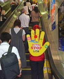 　名古屋市営地下鉄の駅で、エスカレーターの立ち止まっての利用を促す「なごやか立ち止まり隊」＝６日