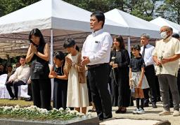 　１５日、フィリピン・ルソン島ラグナ州のカリラヤ日本人戦没者慰霊園で、献花し手を合わせる参列者（共同）