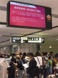 　新千歳空港で保安検査中断の案内を表示するモニター＝１７日午後