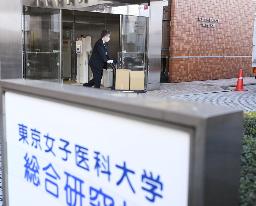 　東京女子医大を家宅捜索し、押収物を運び出す警視庁の捜査員ら＝３月、東京都新宿区