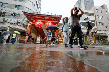 　雨の中、名古屋市の繁華街・大須を歩く人たち＝３１日午後