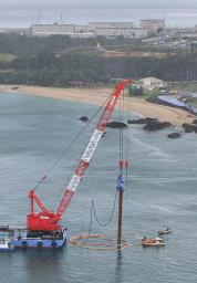 　沖縄県名護市辺野古沖の大浦湾で、金属製のくいを打ち込むクレーン船＝８月