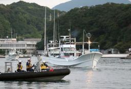 　海保のゴムボート（手前）に見守られ、イルカなどの追い込み漁に向かう漁船＝５日早朝、和歌山県太地町