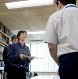 　北海道の鈴木直道知事に対して謝罪などを求める要請書を、道の担当者（右）に提出する桃井希生さん＝９日午後、道庁