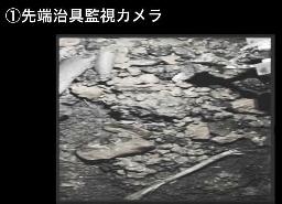 　原子炉格納容器の底部に広がる小石状のデブリの一つを爪形装置（右上）でつかんで持ち上げる様子＝９月１４日（東京電力提供）