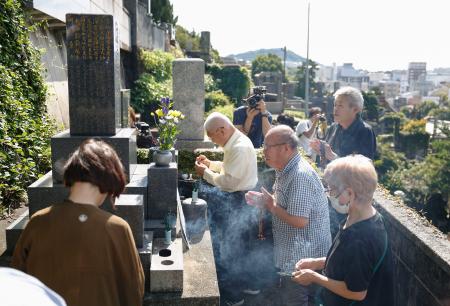 　渡辺千恵子さんの墓前で手を合わせる長崎原爆被災者協議会のメンバーら＝１２日午後、長崎市