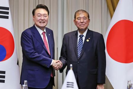 　会談を前に握手する石破首相（右）と韓国の尹錫悦大統領＝１６日、ペルー・リマ（代表撮影・共同）