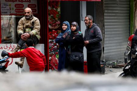 　２５日、レバノンの首都ベイルートで、イスラエル軍の攻撃を受けた現場周辺に集まる人たち（ロイター＝共同）