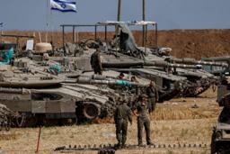 　１４日、イスラエルとパレスチナ自治区ガザとの境界近くで、戦車付近にいるイスラエル兵（ロイター＝共同）