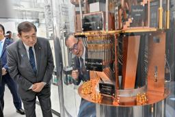 　産業技術総合研究所の量子・ＡＩ融合技術ビジネス開発グローバル研究センターで、超電導型量子コンピューターの内部模型を前に説明を受ける石破首相（左）＝１８日午後、茨城県つくば市（代表撮影）