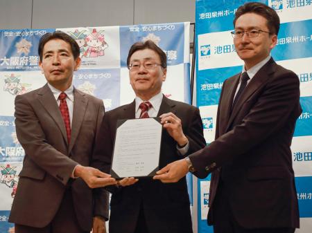 　締結式で写真に納まる池田泉州銀行の藤原孝嘉取締役常務執行役員（中央）ら＝２６日、大阪府警本部