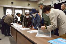 　引き揚げの乗船名簿を見る元島民ら関係者＝２６日午後、札幌市