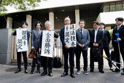 　大川原化工機への捜査を巡る訴訟の控訴審判決を受け、「全面勝訴」と書かれた紙を手にする大川原正明社長（左から３人目）ら＝２８日午後、東京高裁前