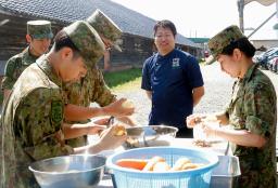 　陸上自衛隊の炊事訓練で、隊員にアドバイスする冨成寿明さん（右から２人目）＝２８日午前、金沢市