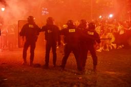 　熱狂したパリ・サンジェルマンのファンへの対応に当たる警官隊＝５月３１日、フランス・パリ（ロイター＝共同）