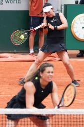 　女子ダブルス準決勝でプレーする穂積絵莉（上）、ウリケ・アイケリ組＝パリ（共同）