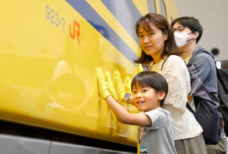 　「ドクターイエロー」Ｔ４編成の搬入イベントで、車両を押す参加者＝７日午前、名古屋市のリニア・鉄道館