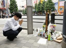 　無差別殺傷事件現場の交差点で手を合わせる男性＝８日午前、東京・秋葉原