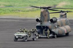 　静岡県の東富士演習場で行われた陸上自衛隊の「富士総合火力演習」でヘリから配置につく自衛隊員ら＝８日午前