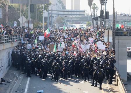 　８日、米ロサンゼルスの幹線道路入り口で対峙する州警察と抗議活動参加者（共同）