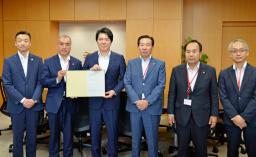 　内閣府を訪れ、西野太亮政務官（左から３人目）に要望書を提出した埼玉県内５市の市長ら＝９日午後