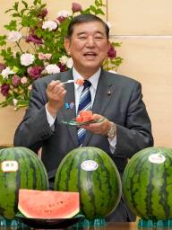 　贈呈されたスイカを試食する石破首相＝１０日午前、首相官邸