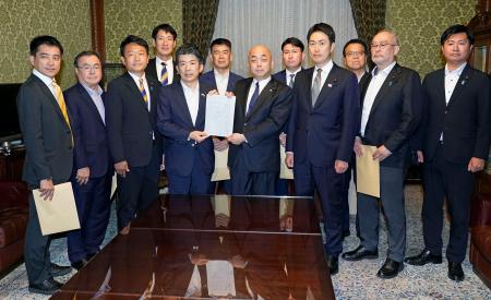 　ガソリン税に上乗せされている暫定税率を廃止する法案を衆院に共同提出する野党７党の議員ら＝１１日午後