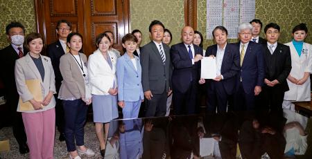 　衆院事務総長（右から７人目）に再審制度を見直す刑事訴訟法改正案を提出する野党６党の議員ら＝１８日午後、国会